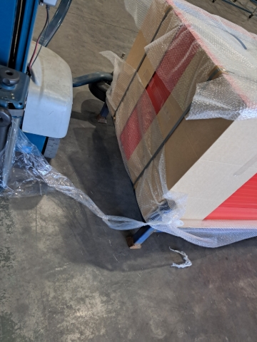 <p>Time to wrap the product.</p><p>Take the end of the plastic wrap and tie it around a leg of the stillage.</p>