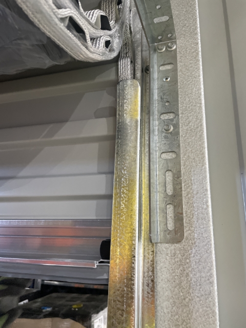 <p>Feed the bottom rail into the track the top of the track and slowly pull down.</p><p>Make sure not to release the door.</p>