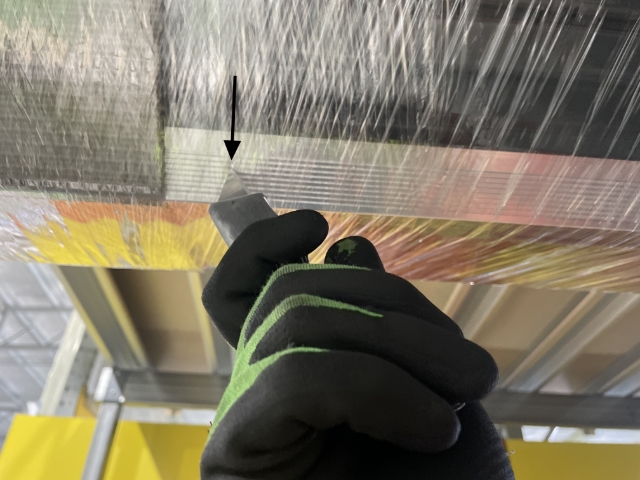 <p>Cut plastic off. Place your blade in the grove of the aluminum bottom rail to ensure you don't scratch the door or cut the rubber.</p>