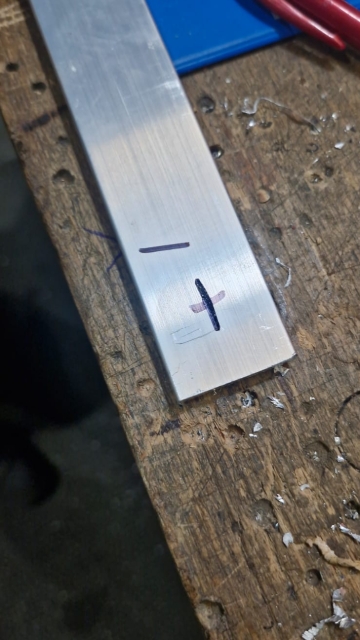 <p>The line is for the bend, and the cross is the mark for where to drill the hole.</p>