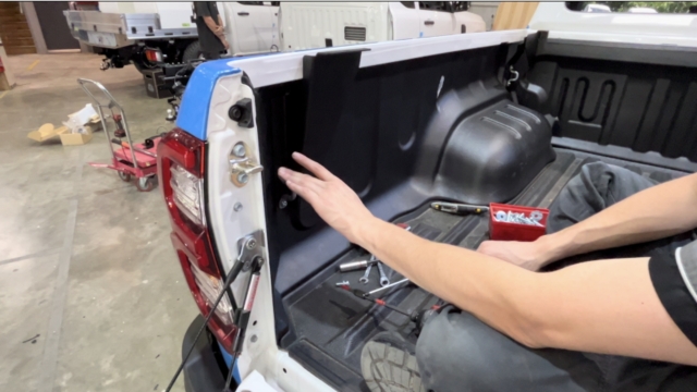 <p>Fit the two rear brackets (CP106364/66) to the wellside using M8 × 25 hex head bolts with M8 washers, loosely tighten the bolts, and refit the original tie-down point if required.</p>
