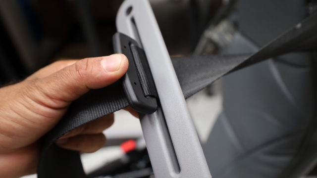 <p>Start to push the seatbelt buckle through the belt guide.</p>