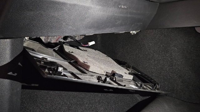<p>1.</p><p>Locate the cover plate beneath the
passenger glove box. Release the
clips (circled yellow), disconnect the
attached plug (circled red) and remove
the cover.</p>