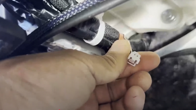 <p>4.</p><p>Locate the loose white plug in the cavity.</p><p>Connect the matching connector from
the supplied harness.</p>
