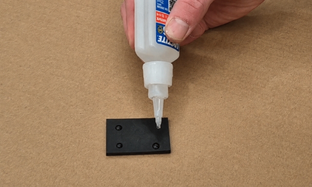 <p>Apply 4 small dots of super glue onto the rubber then quickly proceed to the next step.</p>