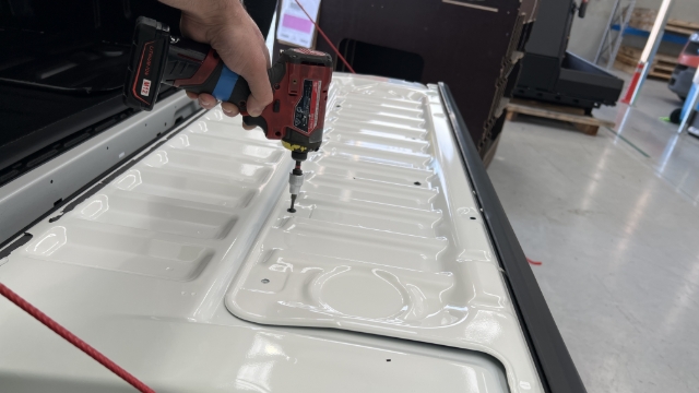 <p>Remove the tailgate backing plate using a T20 torx screwdriver.</p>