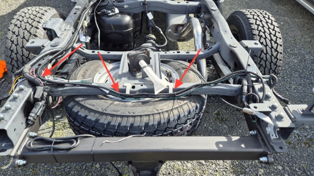 <p>Route across the rear cross-member, securing to the factory wiring. Cable tie on the hinge point where this starts routing towards the front of the vehicle.</p>