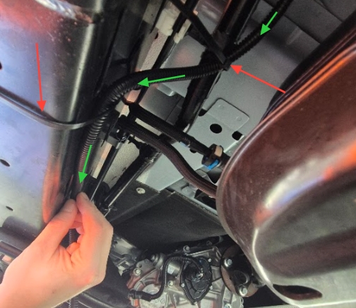 <p>Transfer from routing along the factory wiring, to securing to the inside of the chassis beam. (cable tie locations indicated by red arrows)</p><p>This is to ensure no contact with vehicle brake or fuel lines</p>