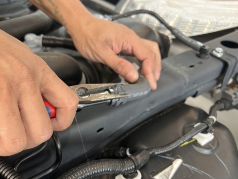 <p>Remove the breather hose clip using pliers.</p>