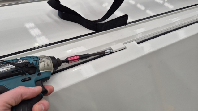 <p>While 2 people lift the door into place, 1 person will need to slide the pins along from the top and secure these in place using an impact driver.</p>