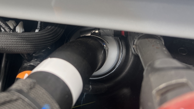 <p>Loosen the hose clamp at the tank-end of the fuel filler pipe with a 7mm socket.</p>