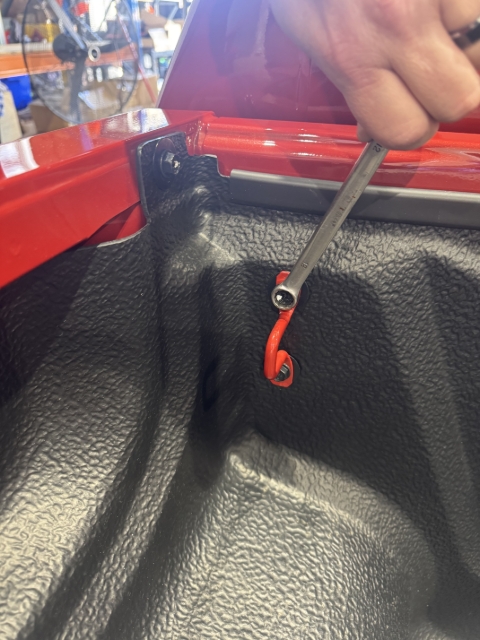 <p>Remove the Two bolts retaining the tie down bracket and tub liner at the front.</p><p>Keep the bolts and the tie down bracket for later.</p>