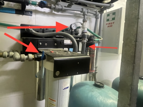 <p><span>Turn off water to the system at the blue valve on the left hand side and release pressure through the flushing valve to the right of the 4 aluminum cartridges.</span></p><p>Ensure the pressure gauge is showing zero before moving to the next step</p>
