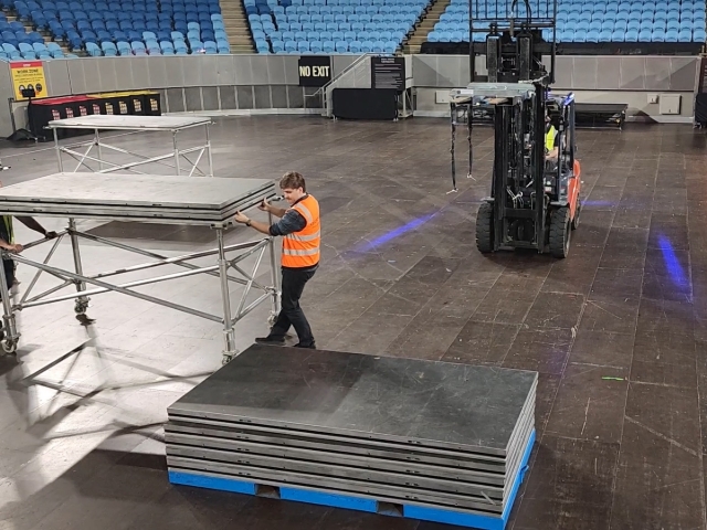 <h1>Setup Workspace</h1><p></p><ul><li><p>Set Down Stage Panel Stillage</p></li><li><p>Line Up Forklift Normal to Long Edge of Stage Panel Stillage</p></li><li><p>Roll Double Stacked Panel Frames to One Side</p></li></ul><p></p>