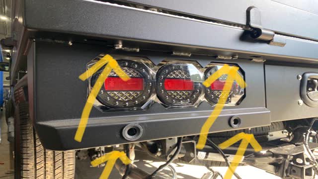 <p>Since this has "Integrated" Tail Light housings, we must remove the lights to access the sensors</p>
<p>Remove the 4 x M6 bolts (shown by yellow arrows) - use 10mm socket.</p>