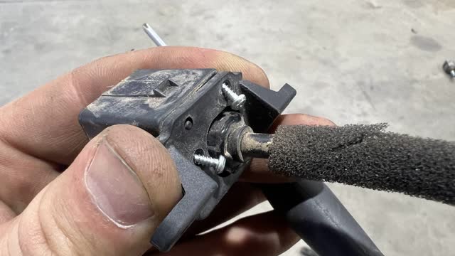 <p>Remove the two small Phillips head screws with a fine screwdriver to remove the plastic bracket from the back of the camera</p>
