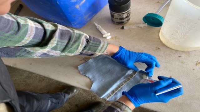 <p>Apply glue to the edges of a denim patch.</p>