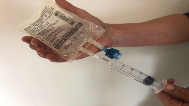<p>Draw out 20 ml saline from bag like this.</p>