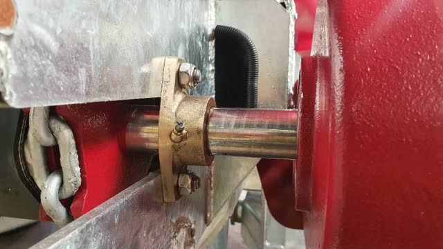 <p>Support drive assembly frame and remove 2 bolts from brass support bushing</p>