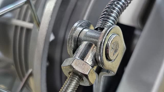 <p>To adjust the rear brake, turn the nut inwards,
It will move the brake shoes closer to the brake drum
There must be free roll of the wheel when brake is not engaged,
The foot should have to put a little pressure on the pedal to engage the rear brakes</p>