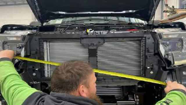 <p>Find a fixed point on the vehicle and opposing side of cradle as shown. Take measurement to square up and centre cradle.
Repeat from left and right fixed points until the cradle is centred.</p>
<p>Tip: Use the inside edge of the headlight as a guide.</p>