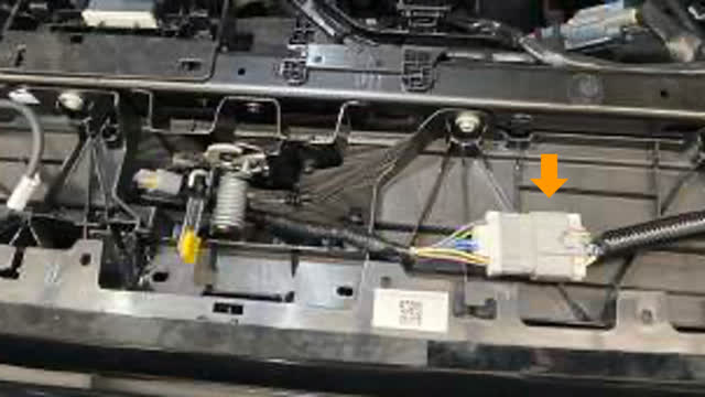 <p>Once the cover is removed, disconnect
front camera wiring, washer nozzle hose (if
applicable) and grey bumper harness.</p>