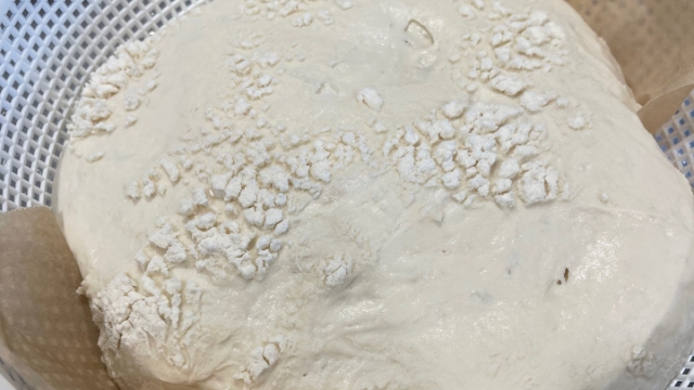 <p>Add baking paper to the inside of a banneton (or mesh-like basket), sprinkle flour lightly on top of the paper, then add the dough parcel with the seam facing up. Sprinkle more flour on top of the dough.</p>
<p>Cover the dough and let it rest for eight to twelve hours in the refrigerator. This will allow the bread to develop the characteristic sourdough flavours.</p>