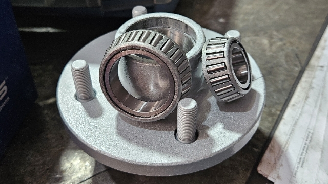 <p>Grease bearings/hubs using grease cone and battery grease gun, assemble hubs.</p>
