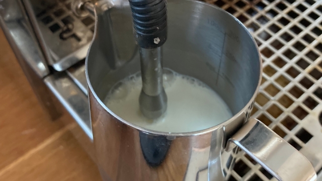 <p>Position the nozzle of the steamer so that it gently touches the surface of the milk. This helps create the desired froth and texture.</p>
