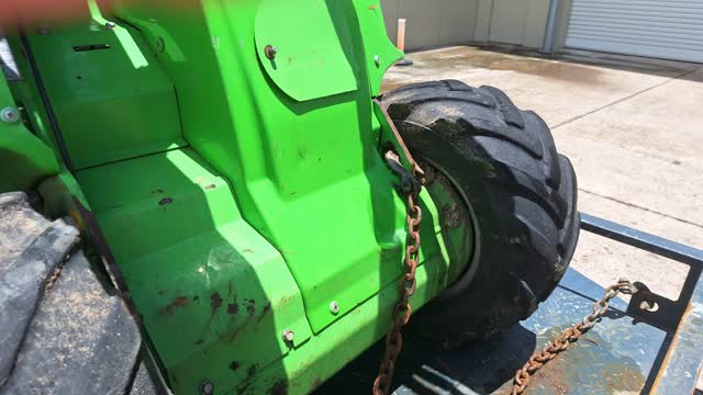 <p>Connect both chains diagonally across from the front trailer anchor points to the opposite front anchor points on the machine as shown.</p>
