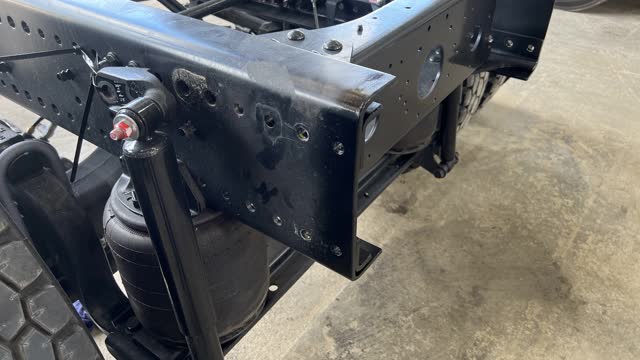 <p>After cutting off excess chassis, tidy up and round edge with a flappy disc. Once completed, clean with brake clean and spray black paint on chassis end and in the drilled holes to prevent rust.</p>