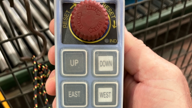 <p>Use the hand held crane remote to move the clamp into position above the reel.</p>
