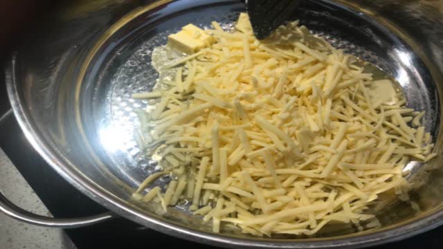 <p>In a saucepan over low heat, combine 2 cups cheese and 1/4 cup butter. Stir occasionally until almost melted.</p>