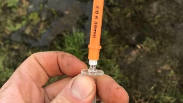 <p>Take needle out of holder and place on end of calcium line</p>