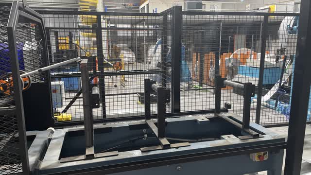<p>Open the cage at the coil end of the top hat machine.</p>