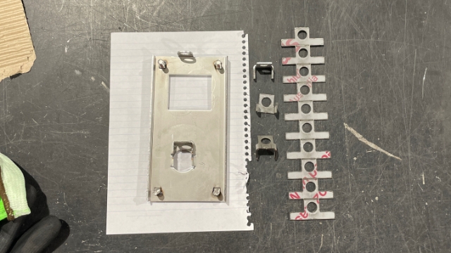 <p>Left; Roller door lock after it has been folded, welded, linished and cleaned.
Right; Roller Door Latch tab in a row and folded, ready for welding.</p>