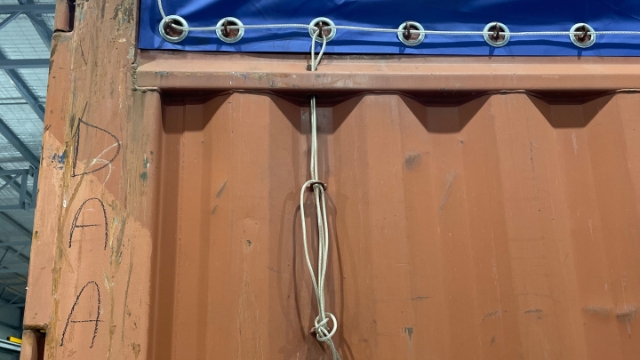 <p>Untie the cord that is attached to the tarp.</p>