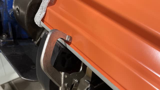 <p>After the door is even, use the clamp secure the door to the wheels.</p>