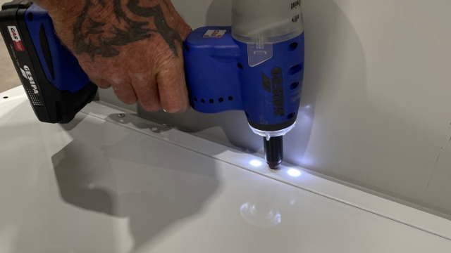 <p>Align the holes and rivet the side panel to the base panel.</p>